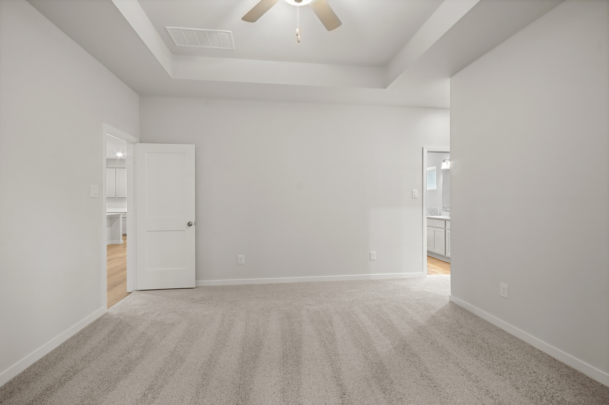 A room with white walls and a ceiling fan.