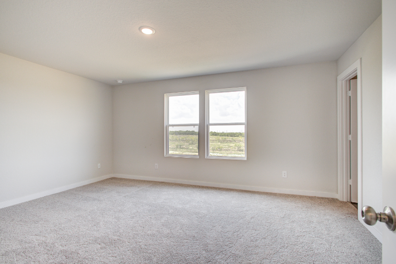 A room with a window and carpet.