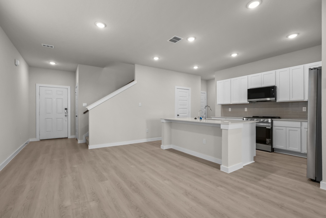 A kitchen with white cabinets.
