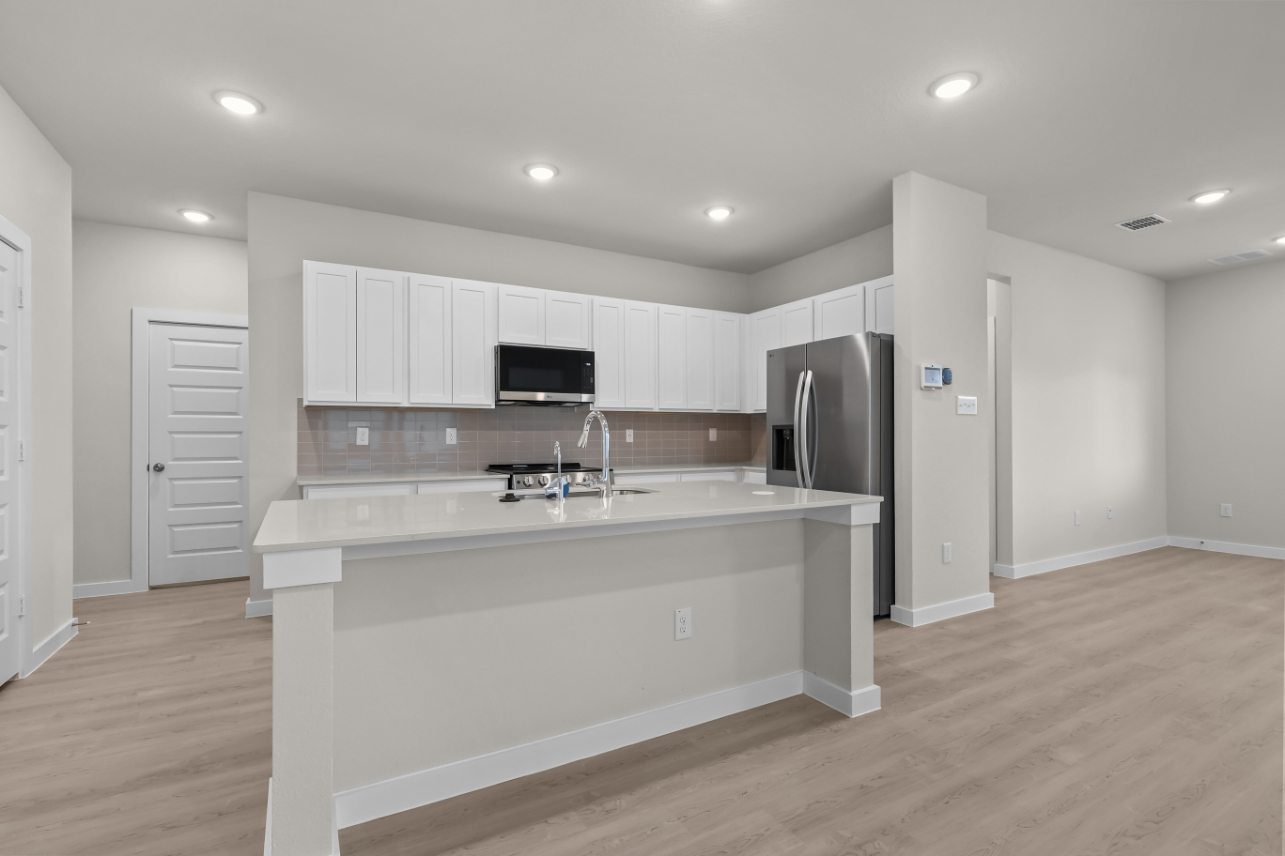 A kitchen with white cabinets.
