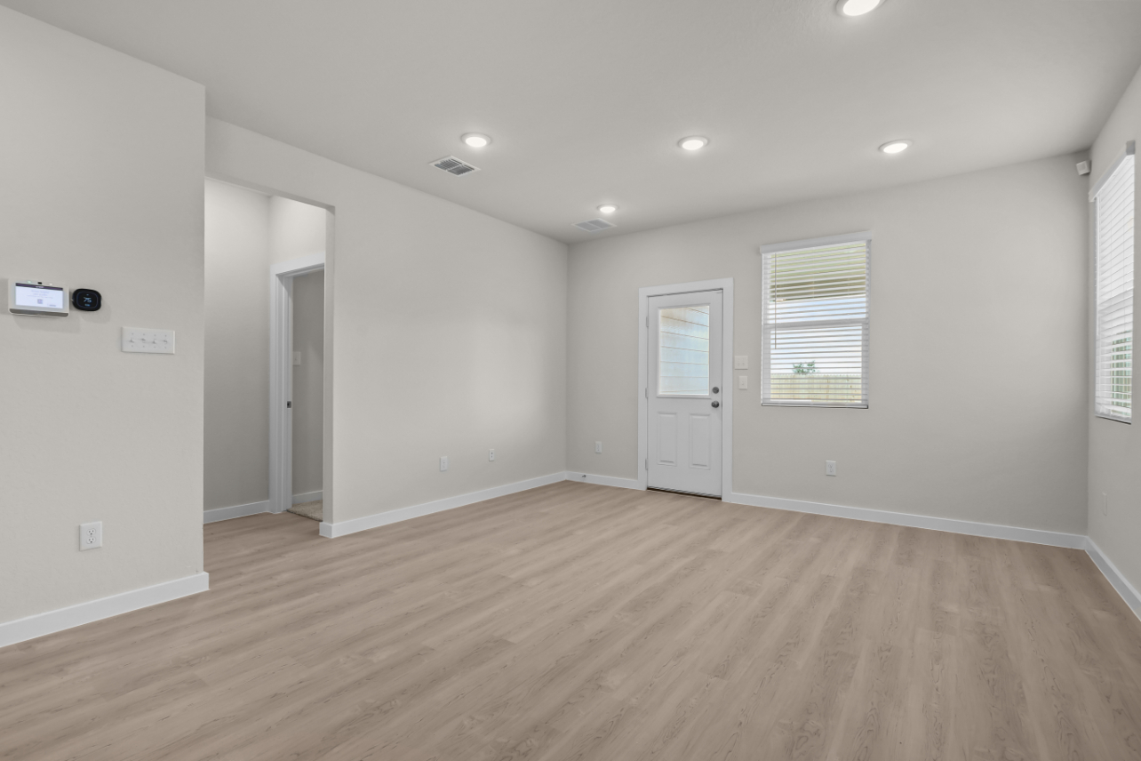 A room with white walls and wood floors.
