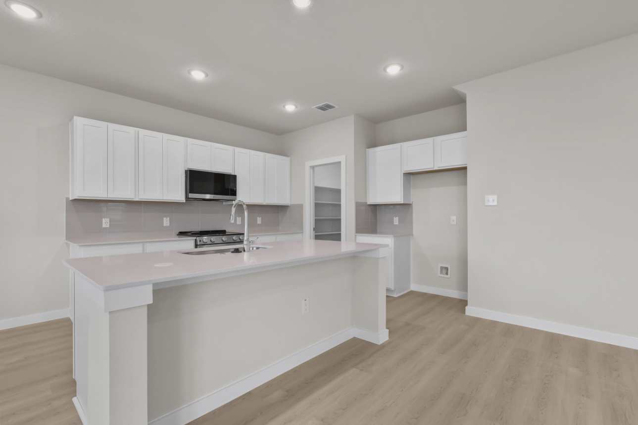 A kitchen with white cabinets.