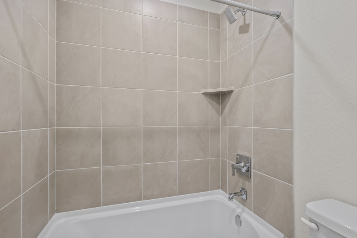 A bathroom with a bathtub and toilet.