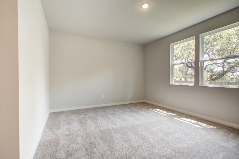 A room with a window and a carpet.