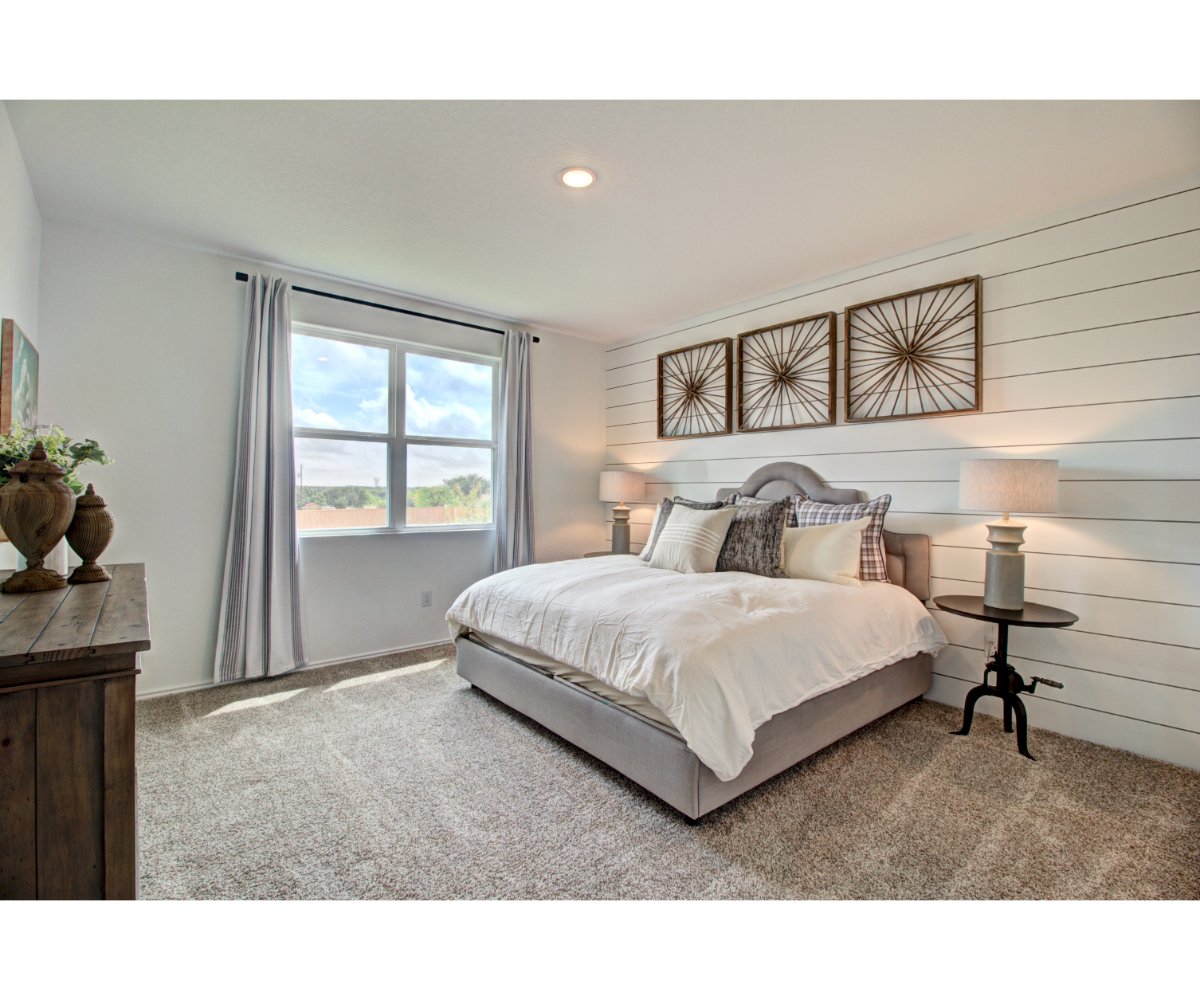 A bedroom with a bed and a window.