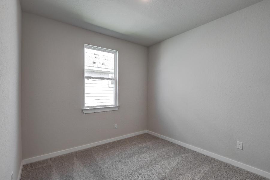 A room with a window and a carpet.