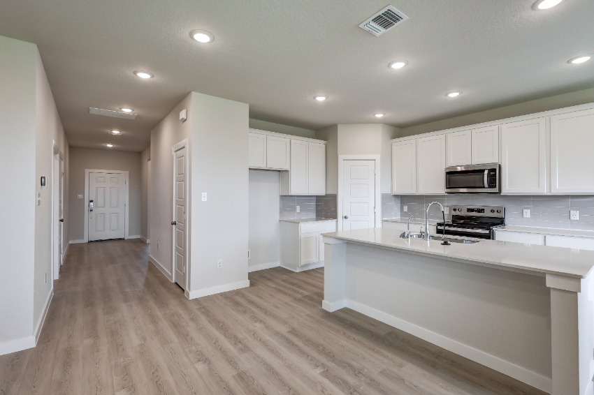 A kitchen with white cabinets.