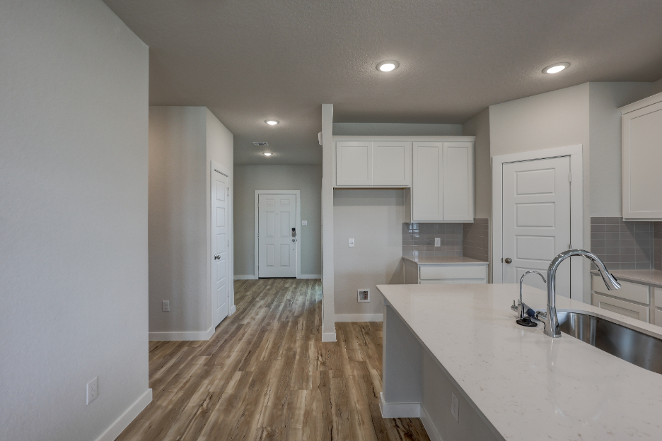 A kitchen with white cabinets.