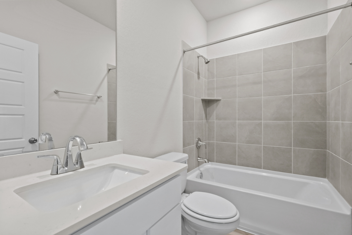 A bathroom with a tub sink and toilet.