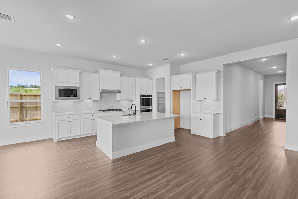 A kitchen with white cabinets.