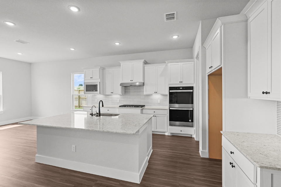 A kitchen with white cabinets.