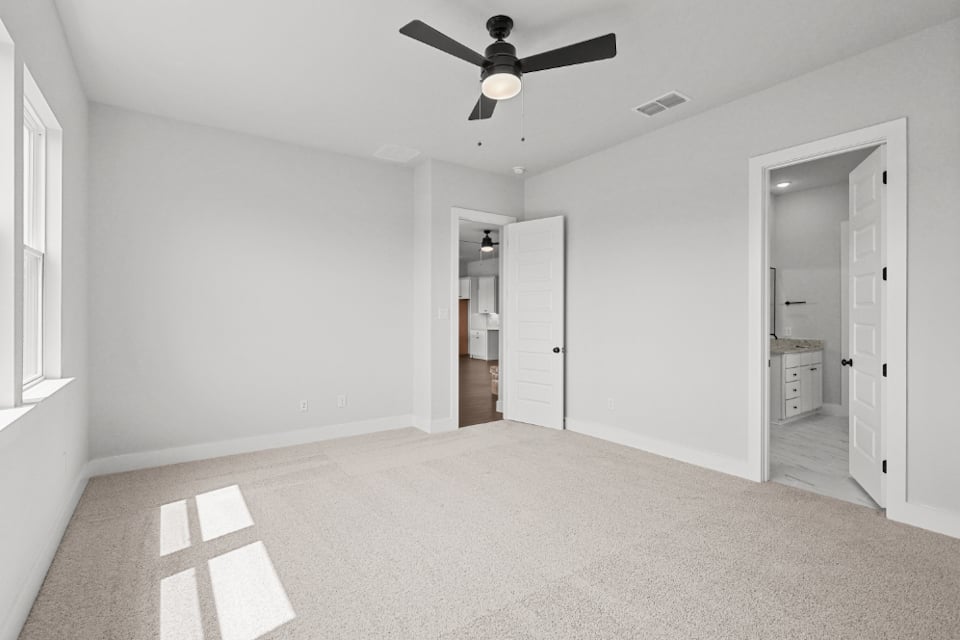 A room with a ceiling fan and a door.