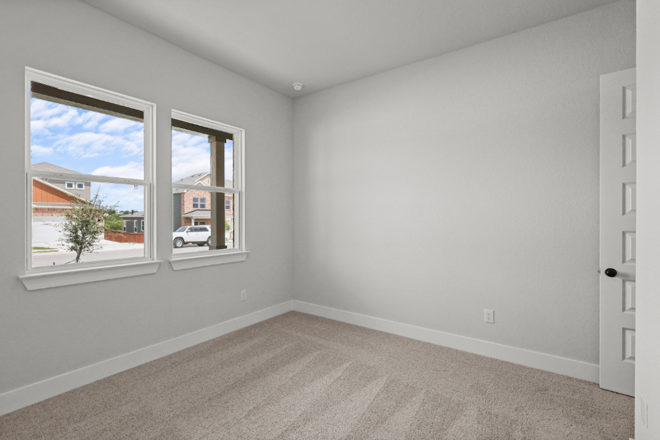 A room with a window and a carpet.