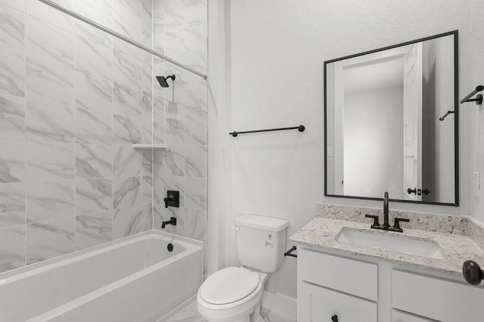 A bathroom with a tub sink and toilet.