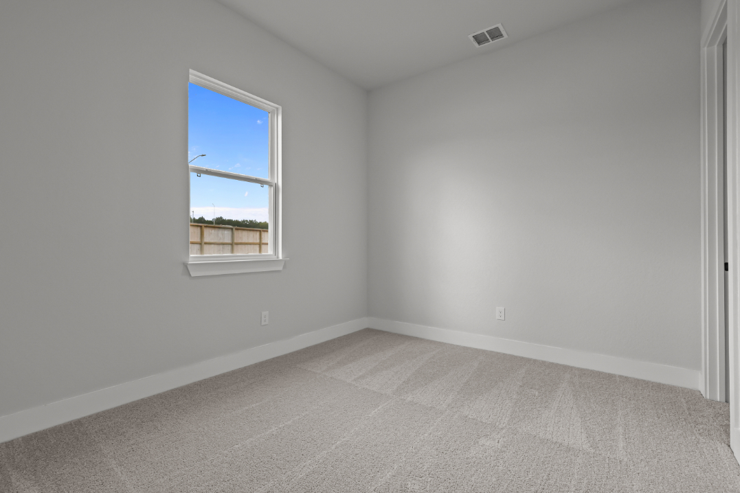 A room with a window and a carpet.