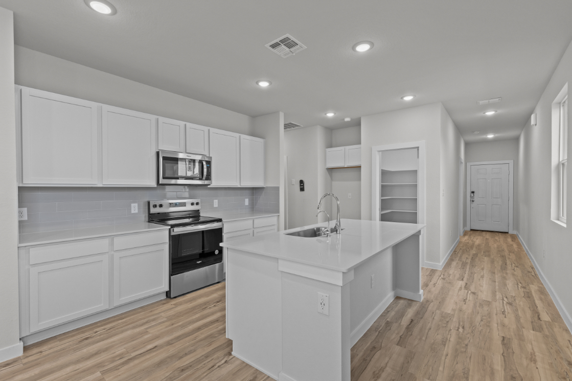 A kitchen with white cabinets.