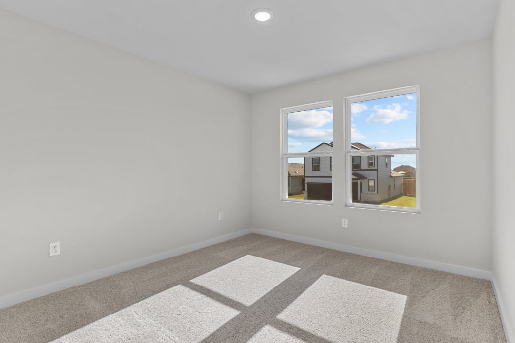 A room with a window and a rug.