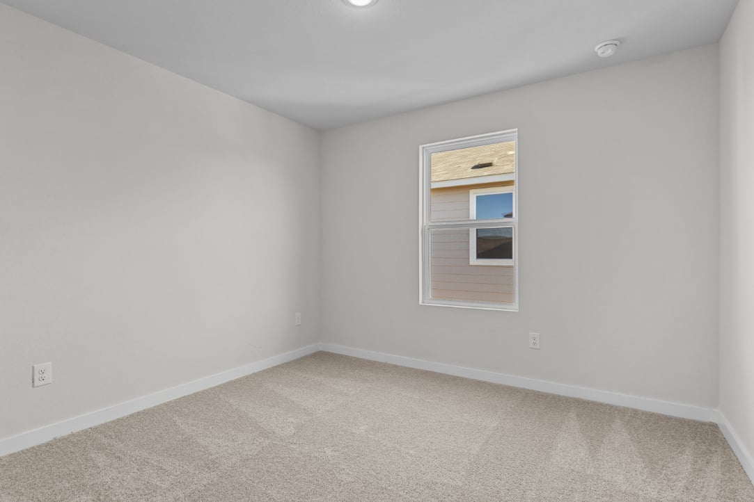 A room with a window and carpet.