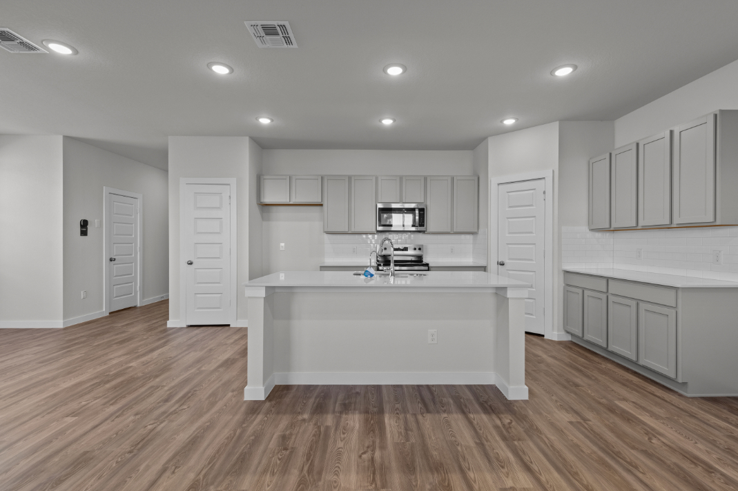 A kitchen with white cabinets.
