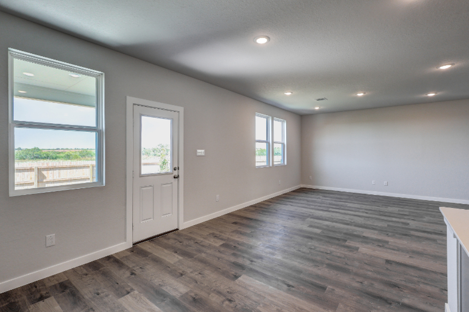 A room with windows and a wood floor.