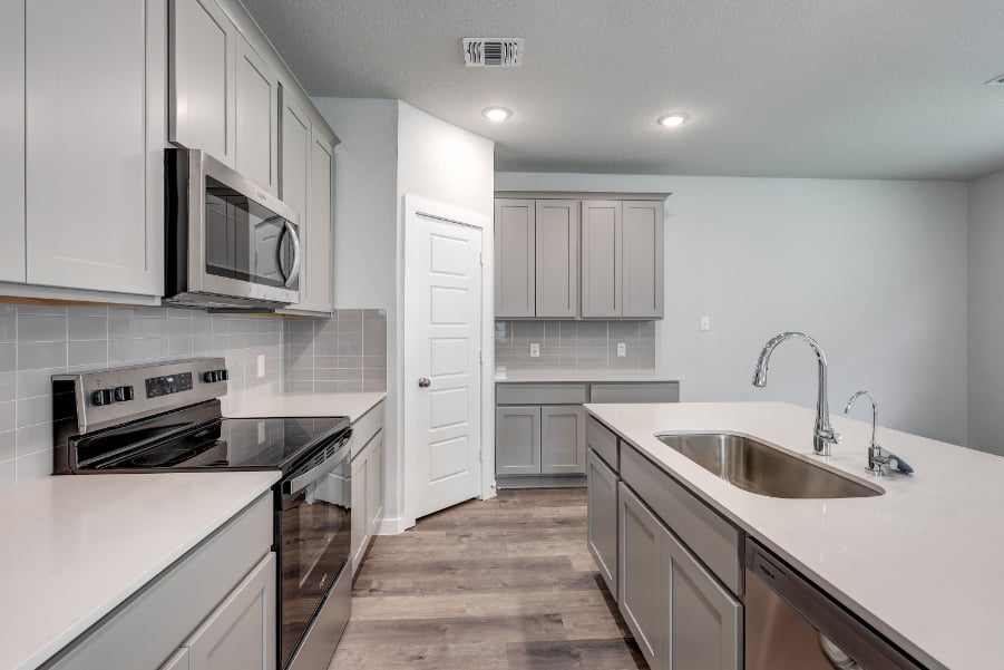 A kitchen with white cabinets.