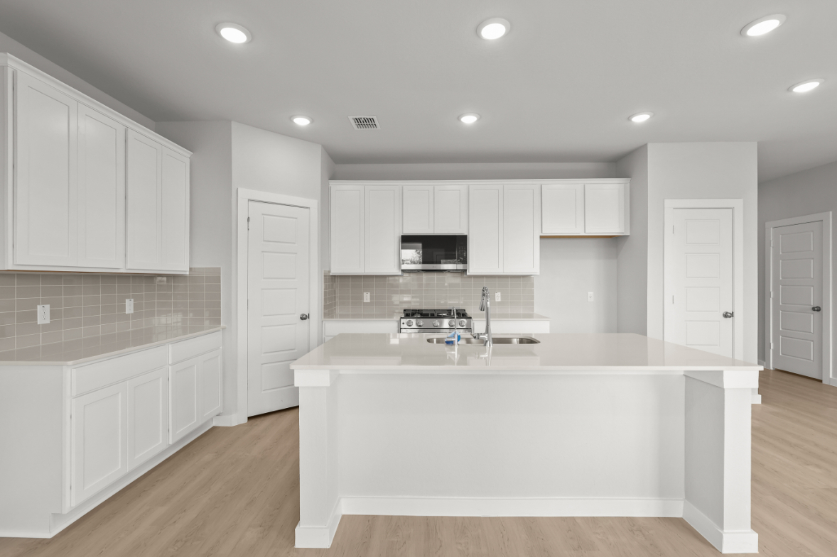 A kitchen with white cabinets.