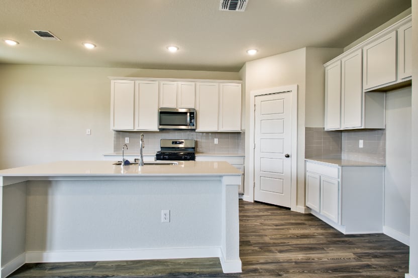 A kitchen with white cabinets.