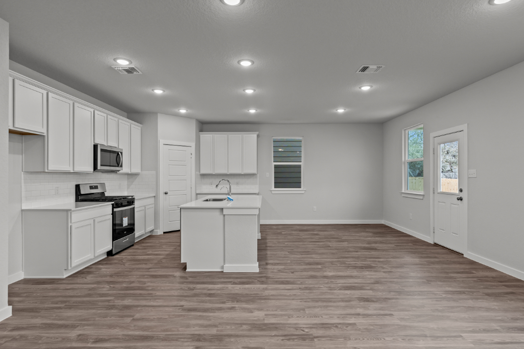 A kitchen with white cabinets.