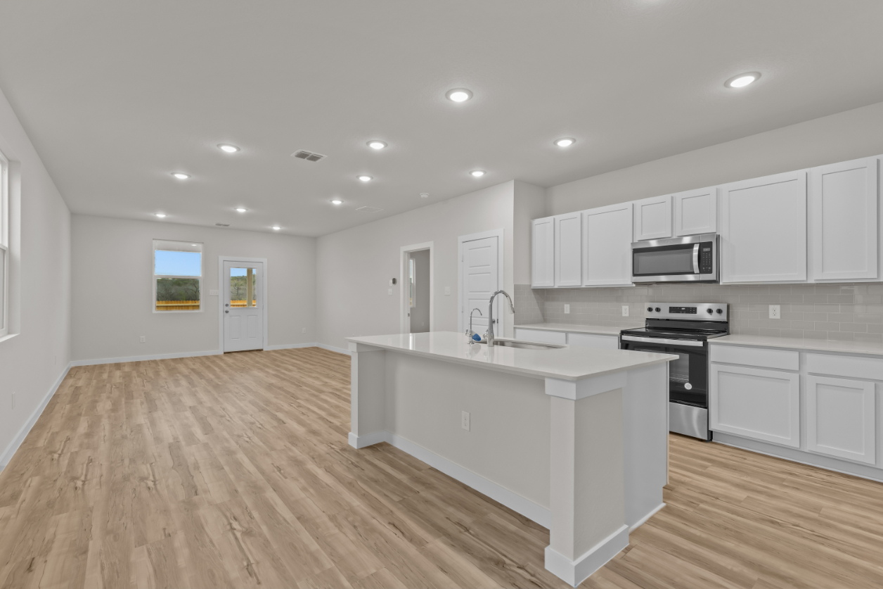 A kitchen with white cabinets.