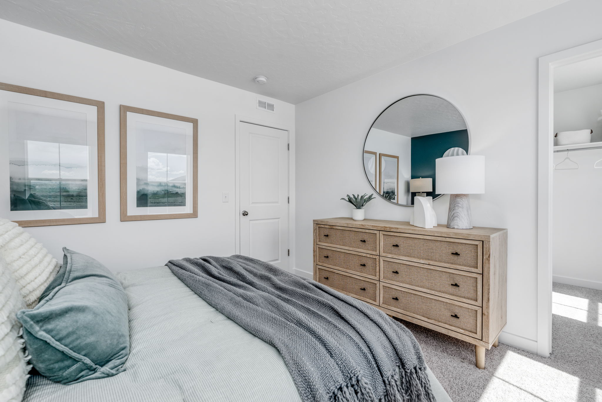 A bedroom with a bed and a mirror.