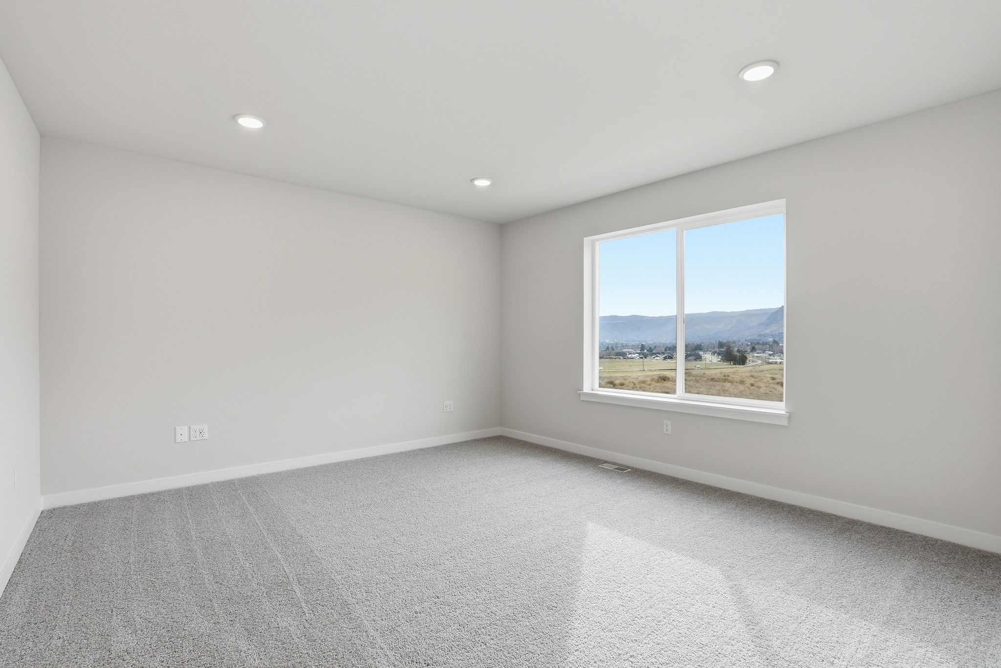 A room with a window and a view of the mountains.