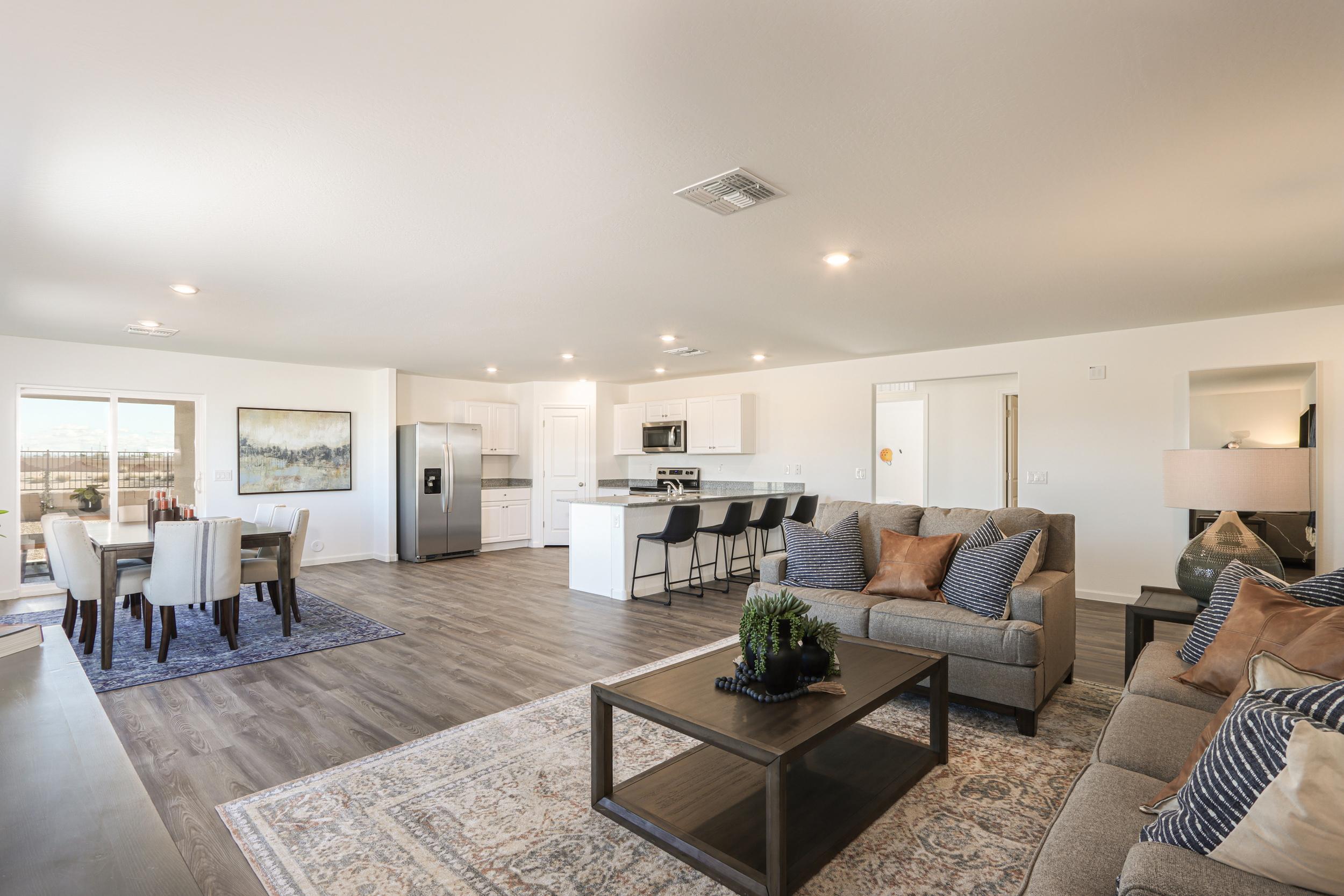A large living room with a large dining room and a large window.