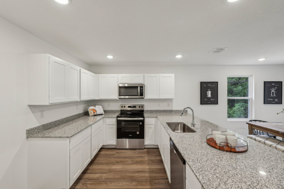 A kitchen with white cabinets.