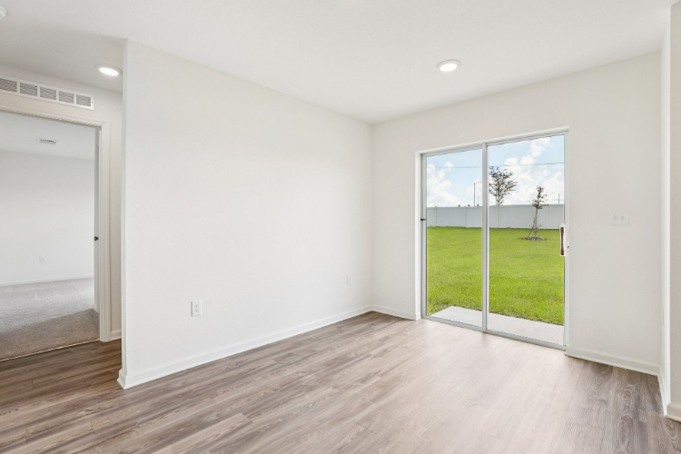 A room with a wood floor and a large window.