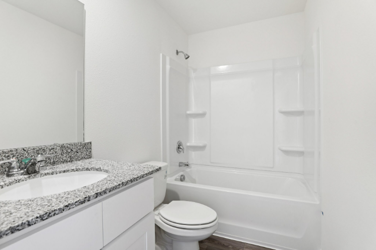 A bathroom with a tub sink and toilet.
