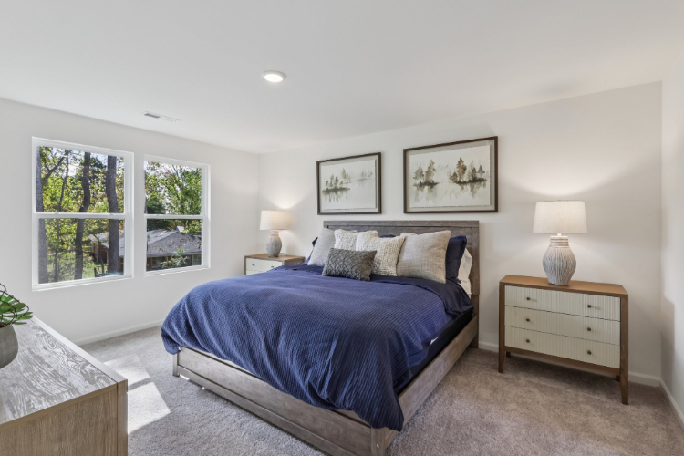 A bedroom with a bed and lamps.