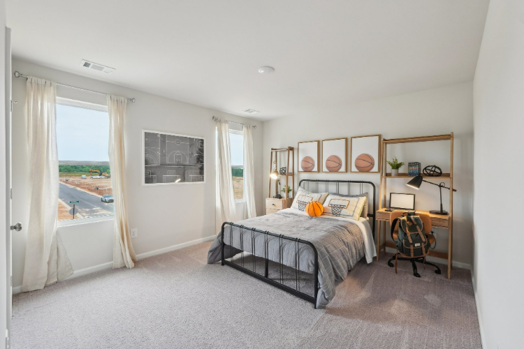 A bedroom with a bed and a desk.