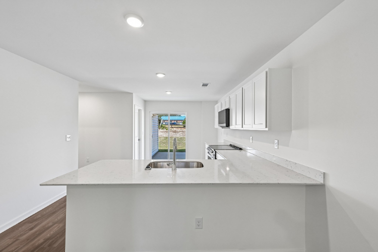 A kitchen with a sink and a mirror.