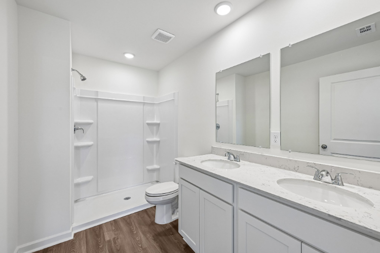 A bathroom with a sink toilet and mirror.