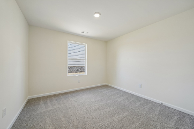 A room with a carpet and a window.