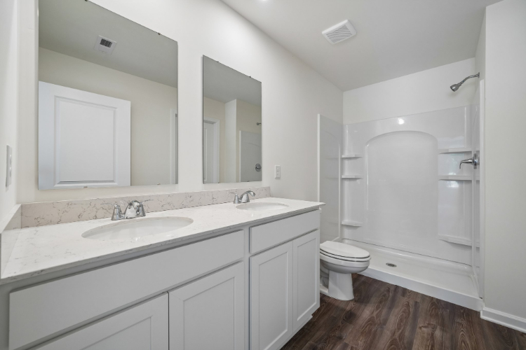 A bathroom with white cabinets.