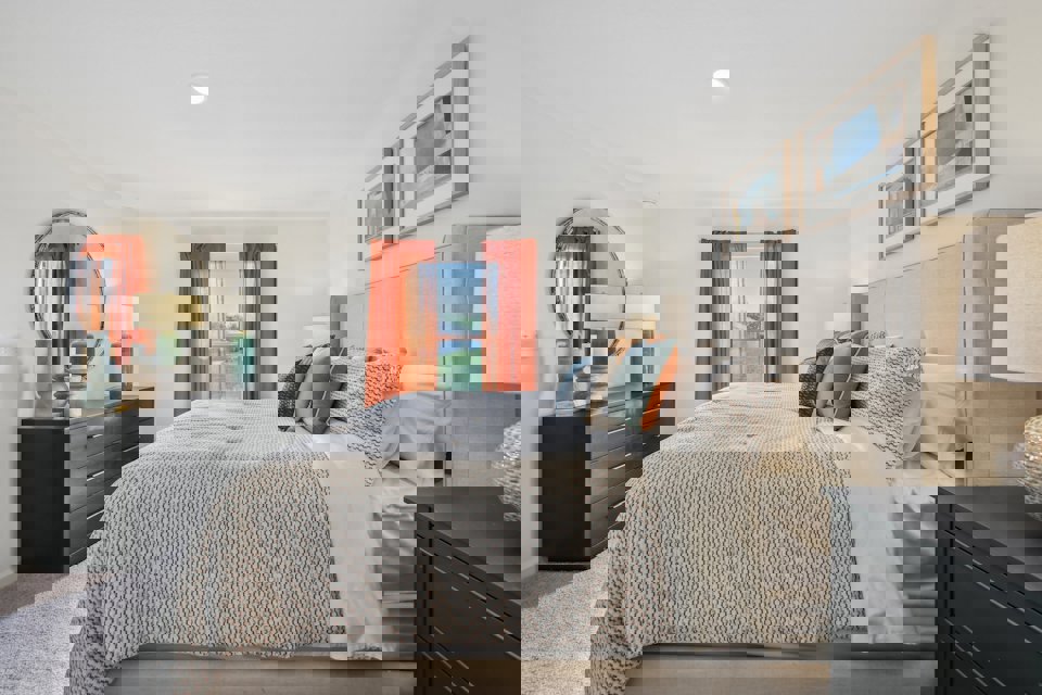 A bedroom with a bed and a mirror.