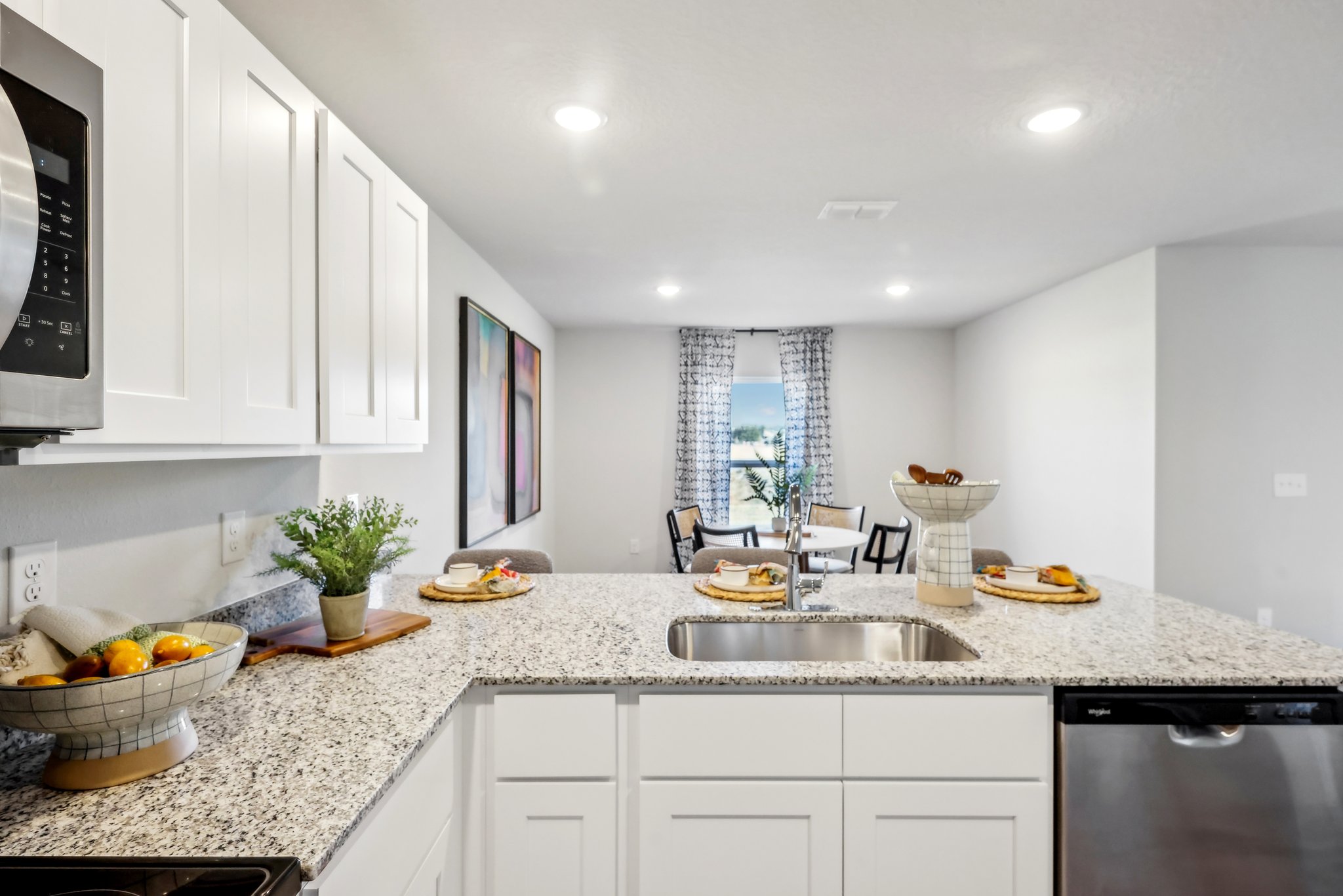 A kitchen with white cabinets.