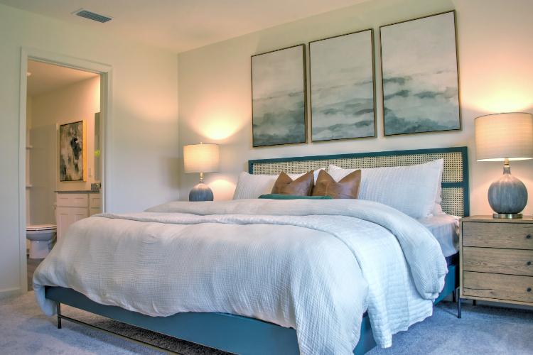 A bed with a blue comforter.