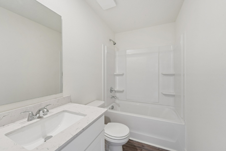 A bathroom with a tub sink and toilet.