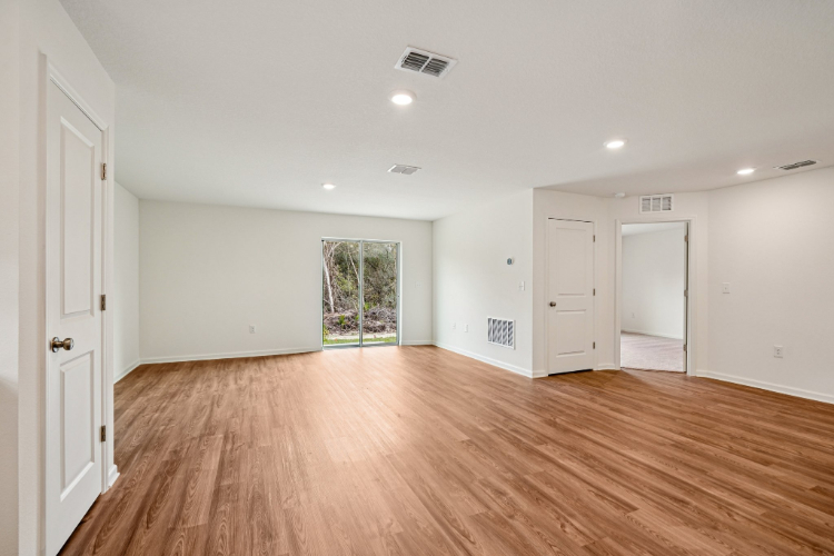 A room with white walls and wood floors.