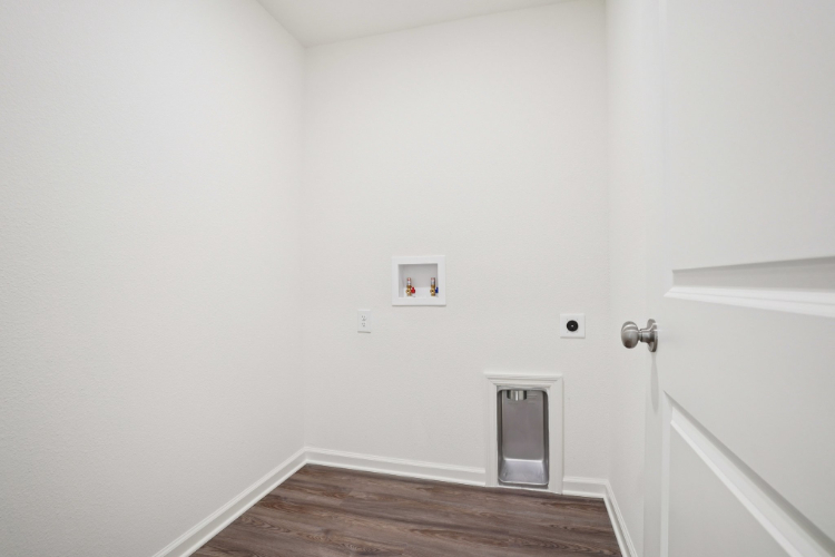 A white room with a wood floor and a white door.