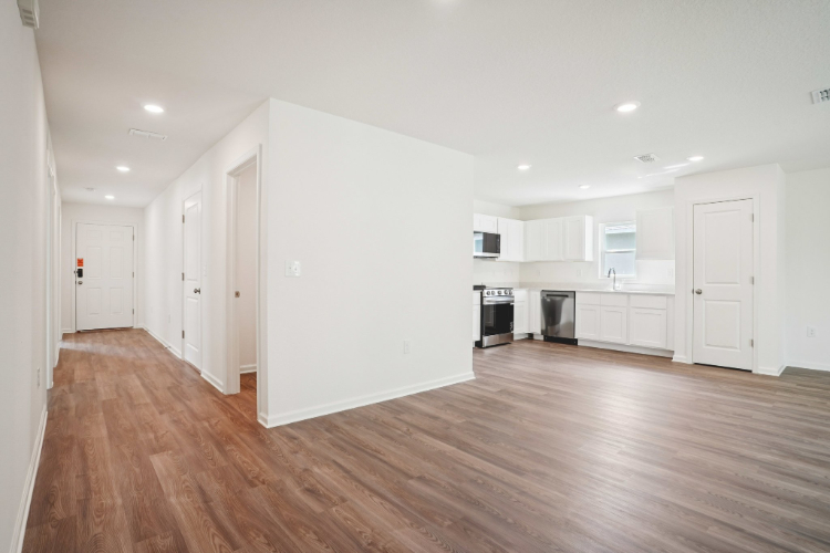 A large empty room with white cabinets.