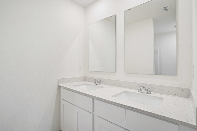 A bathroom with white cabinets.