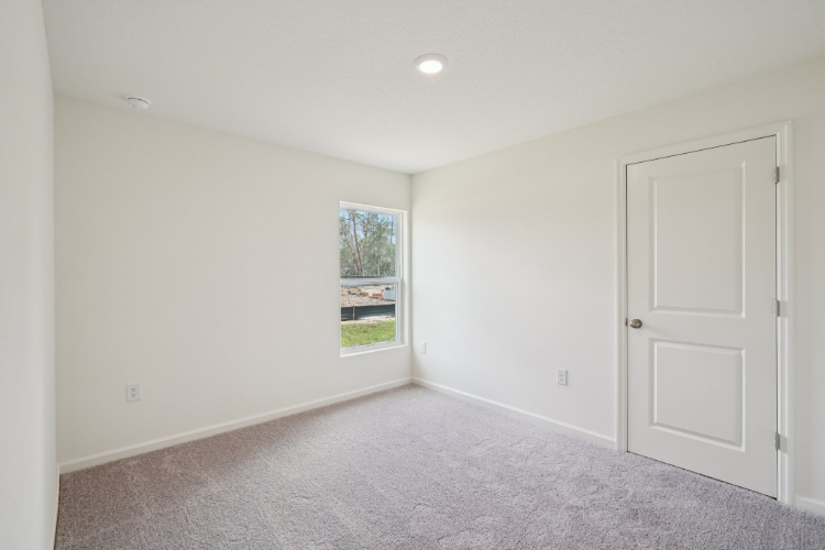 A room with white walls and a window.